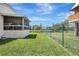 Backyard with a screened-in porch, a lush lawn, and a sturdy green chain-link fence offering privacy and security at 6603 S Juanita St, Tampa, FL 33616