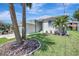 Single-story home boasts a well-kept lawn with tropical palm trees enhancing its curb appeal at 6603 S Juanita St, Tampa, FL 33616