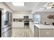 Modern kitchen featuring white cabinets, stainless steel appliances, and a marble countertop island at 6603 S Juanita St, Tampa, FL 33616