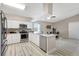 Modern kitchen featuring white cabinets, stainless steel appliances, and an open dining area at 6603 S Juanita St, Tampa, FL 33616