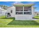 Cozy screened porch with a lattice base, offering a relaxing outdoor space adjacent to the lush green lawn at 6603 S Juanita St, Tampa, FL 33616