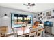 Bright dining room features a ceiling fan and sliding doors to a screened-in pool area at 7305 Jasmine Blvd, Port Richey, FL 34668