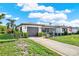 Charming home exterior featuring well-maintained landscaping, flowering bushes, and an American flag at 7305 Jasmine Blvd, Port Richey, FL 34668