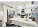 A spacious kitchen with quartz counters, stainless steel appliances, pendant lighting and breakfast bar with seating at 7305 Jasmine Blvd, Port Richey, FL 34668