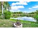 Pond with natural landscaping and small stone fire pit for backyard entertaining at 7305 Jasmine Blvd, Port Richey, FL 34668