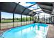 Beautiful in-ground pool is screened in and ready for year-round swimming with blue skies overhead at 7305 Jasmine Blvd, Port Richey, FL 34668
