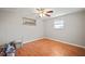 Bedroom with ceiling fan, wood floor, and multiple windows for plenty of sunlight at 7415 Ingleside Dr, Port Richey, FL 34668