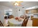 A sunny dining area with a ceiling fan, wood table, and easy access to the kitchen and living room at 7415 Ingleside Dr, Port Richey, FL 34668