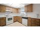 The kitchen includes wood cabinets, tile flooring, and white appliances at 7415 Ingleside Dr, Port Richey, FL 34668