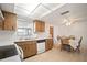 A well lit kitchen and dining area featuring tile floors and wood cabinetry at 7415 Ingleside Dr, Port Richey, FL 34668