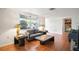 A bright living room featuring wood floors, natural light, and a gray sofa set at 7415 Ingleside Dr, Port Richey, FL 34668