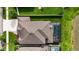 Aerial view of the home showcasing the roof, pool area, screened enclosure, and surrounding landscaping at 7570 Sweeter Tide Trl, Wesley Chapel, FL 33545