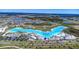 Stunning aerial view of a community lagoon with crystal-clear blue waters and modern amenities at 7570 Sweeter Tide Trl, Wesley Chapel, FL 33545