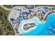 Aerial view showcases beach area with white sand, clear waters, lounge chairs, and volleyball court at 7570 Sweeter Tide Trl, Wesley Chapel, FL 33545