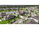 Aerial view of the neighborhood showcasing a home near a pond and lake in a residential area at 7570 Sweeter Tide Trl, Wesley Chapel, FL 33545