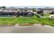 Rear view of a home with pool, a patio, and a screened enclosure, all overlooking a pond at 7570 Sweeter Tide Trl, Wesley Chapel, FL 33545