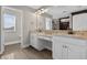 Bathroom with double vanity, granite countertops, framed mirrors, and walk-in closet with wooden floors at 7570 Sweeter Tide Trl, Wesley Chapel, FL 33545