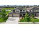 Two-story home exterior with a well-manicured lawn and an attached two car garage with stone details at 7570 Sweeter Tide Trl, Wesley Chapel, FL 33545