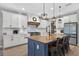 Spacious kitchen boasts a large island, modern appliances, white cabinetry, and pendant lighting creating a functional space at 7570 Sweeter Tide Trl, Wesley Chapel, FL 33545