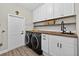 Well-appointed laundry room with custom cabinets, butcher block countertops, modern appliances, and ample storage space at 7570 Sweeter Tide Trl, Wesley Chapel, FL 33545
