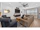 Comfortable living room features shiplap fireplace, a ceiling fan, ample seating, and a large window offering natural light at 7570 Sweeter Tide Trl, Wesley Chapel, FL 33545