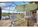 Entertain with ease using the outdoor kitchen and stainless steel grill by the screened-in pool at 7570 Sweeter Tide Trl, Wesley Chapel, FL 33545