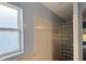 Bathroom featuring a shower with glass block, and a window at 7705 Nottinghill Sky Dr, Apollo Beach, FL 33572