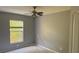 Bedroom with a ceiling fan, neutral wall color, and large window at 7705 Nottinghill Sky Dr, Apollo Beach, FL 33572