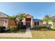 Charming single Gathering home boasting lush landscaping, mature palm trees and a double door entryway at 7705 Nottinghill Sky Dr, Apollo Beach, FL 33572