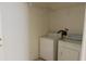 Bright laundry room featuring a washer, dryer, and shelving for storage at 7705 Nottinghill Sky Dr, Apollo Beach, FL 33572
