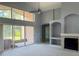 Bright living room boasts vaulted ceilings, fireplace, and large sliding glass doors to the lanai at 7705 Nottinghill Sky Dr, Apollo Beach, FL 33572