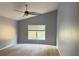 Main bedroom featuring carpet, neutral paint, a window, and ceiling fan at 7705 Nottinghill Sky Dr, Apollo Beach, FL 33572