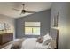 Staged main bedroom with a large bed, window, and decorative wall art at 7705 Nottinghill Sky Dr, Apollo Beach, FL 33572