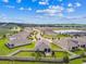 Aerial view of homes in a well maintained community with green lawns, privacy fences, and a tranquil pond at 8174 Wheat Stone Dr, Zephyrhills, FL 33540