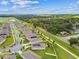 Aerial view of homes in a well maintained community with green lawns and tranquil pond in the distance at 8174 Wheat Stone Dr, Zephyrhills, FL 33540
