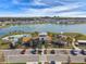 Aerial view of community clubhouse and pool overlooking a scenic lake with a fountain on a clear day at 8174 Wheat Stone Dr, Zephyrhills, FL 33540