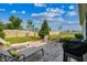A beautifully landscaped backyard features a paver patio, lounge chairs, a barbecue, and well-maintained lawn at 8174 Wheat Stone Dr, Zephyrhills, FL 33540