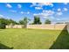 This expansive backyard is surrounded by a stucco wall and features a lush lawn with mature trees at 8174 Wheat Stone Dr, Zephyrhills, FL 33540