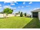 A spacious backyard features lush green grass and mature landscaping, providing a private outdoor oasis at 8174 Wheat Stone Dr, Zephyrhills, FL 33540