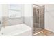 Bright bathroom offers a tub and a glass-enclosed shower at 8174 Wheat Stone Dr, Zephyrhills, FL 33540
