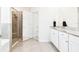 Bright bathroom featuring double granite-topped vanity and a glass-enclosed shower at 8174 Wheat Stone Dr, Zephyrhills, FL 33540