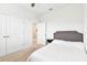Bedroom features neutral carpet, ceiling fan, desk and chair, queen sized bed with grey headboard, and closet doors at 8174 Wheat Stone Dr, Zephyrhills, FL 33540