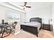 Cozy bedroom featuring a dark wood bed frame, a ceiling fan, and a dedicated workspace at 8174 Wheat Stone Dr, Zephyrhills, FL 33540