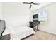 Neutral carpet in a bedroom with a ceiling fan, desk with computer, 2 monitors, and a bed with a grey headboard at 8174 Wheat Stone Dr, Zephyrhills, FL 33540
