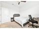 Bedroom includes neutral carpet, ceiling fan, desk and chair, queen sized bed with grey headboard and side table at 8174 Wheat Stone Dr, Zephyrhills, FL 33540