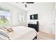 This bedroom has neutral carpet, a ceiling fan, dresser, TV and bright light from two windows with blinds at 8174 Wheat Stone Dr, Zephyrhills, FL 33540
