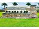 A detailed shot of the stone and mosaic tile Abbot Park community entrance sign framed by green grass and palm trees at 8174 Wheat Stone Dr, Zephyrhills, FL 33540