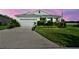 Well maintained single-story home at dusk featuring mature landscaping and a two-car garage at 8174 Wheat Stone Dr, Zephyrhills, FL 33540