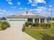 Charming single-story home with beautiful landscaping and a well-maintained lawn under a sunny, partly cloudy sky at 8174 Wheat Stone Dr, Zephyrhills, FL 33540
