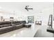 Spacious living room with a large leather sofa and sliding doors to the outdoor space at 8174 Wheat Stone Dr, Zephyrhills, FL 33540